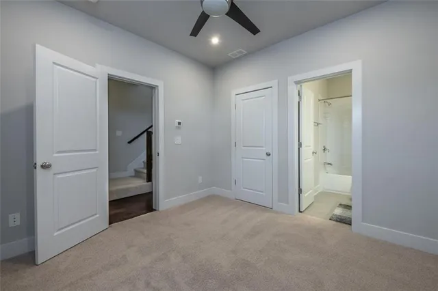 an empty room with closet and a chandelier fan