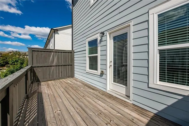 a view of backyard with wooden deck and a potted plant