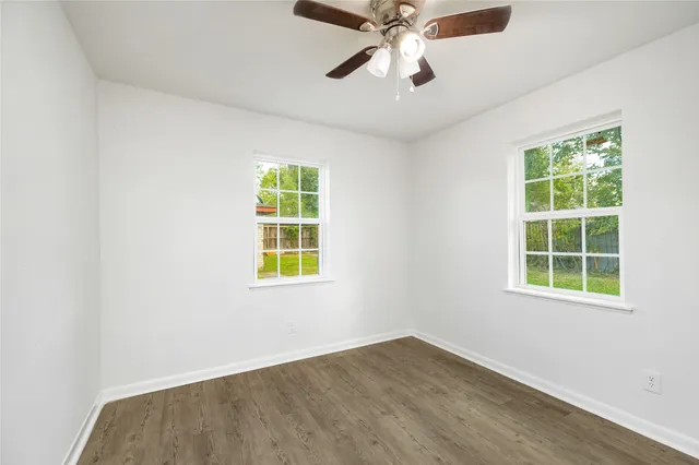 an empty room with a window and a fan