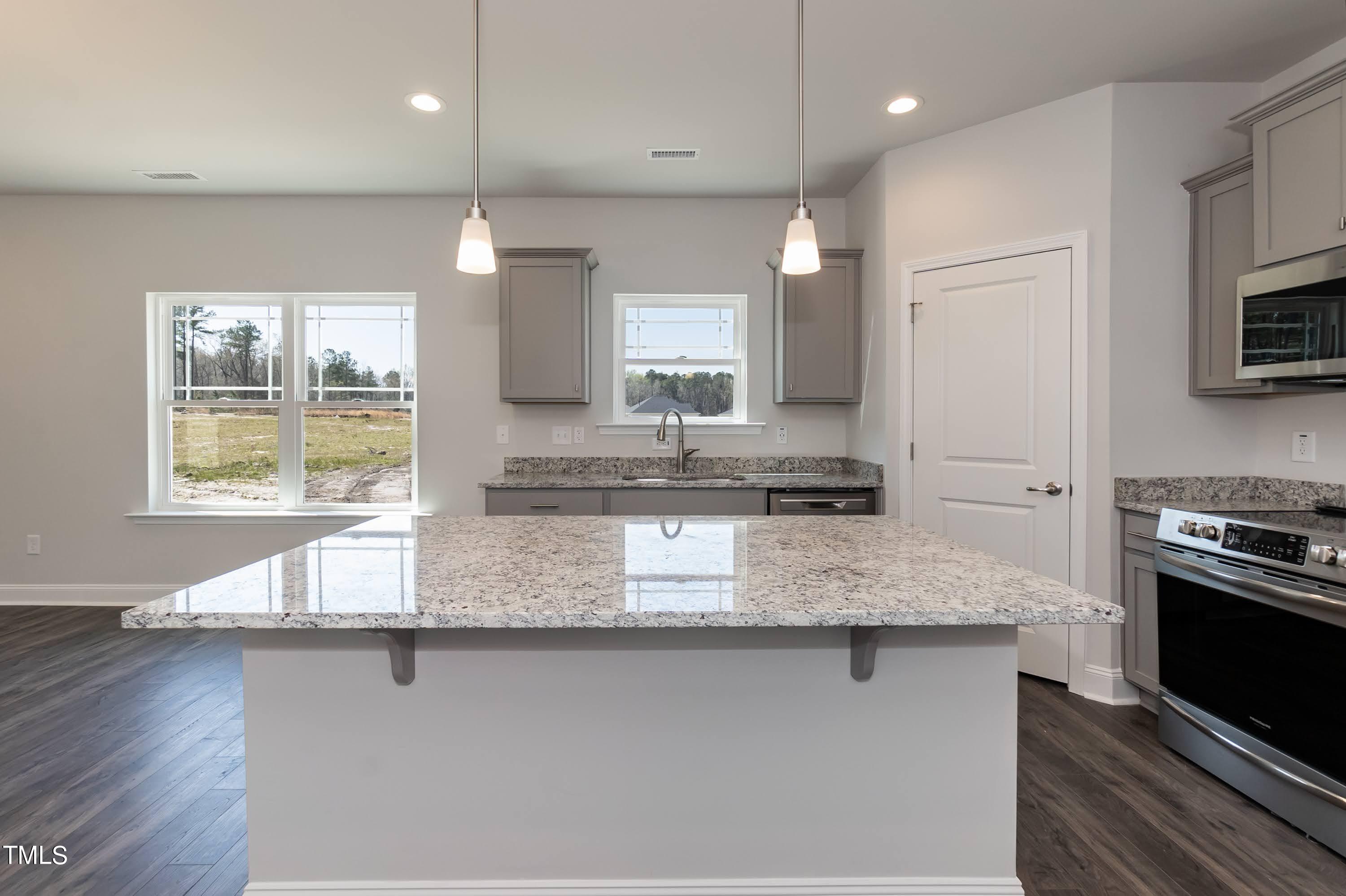 45 High Hampton Way Fuquay-Varina, NC 27526 - Photo 9 of 43 a kitchen with stainless steel appliances granite countertop a sink a stove a microwave a counter space and cabinets
