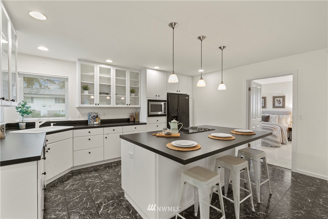 604 216th Street Southwest Bothell, WA 98021 - Photo 22 of 33 a kitchen with a dining table chairs and white cabinets