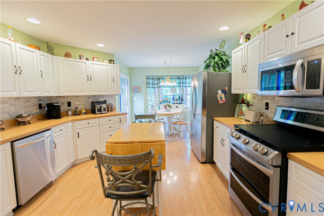 401 Loyalist Drive Ruther Glen, VA 22546 - Photo 17 of 44 a kitchen with stainless steel appliances granite countertop a stove a sink dishwasher and a refrigerator