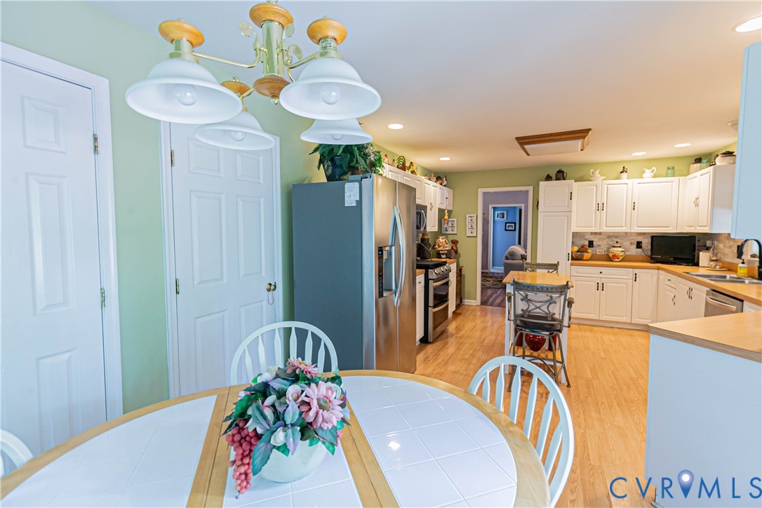 401 Loyalist Drive Ruther Glen, VA 22546 - Photo 19 of 45 a view of a dining room with furniture a chandelier and wooden floor