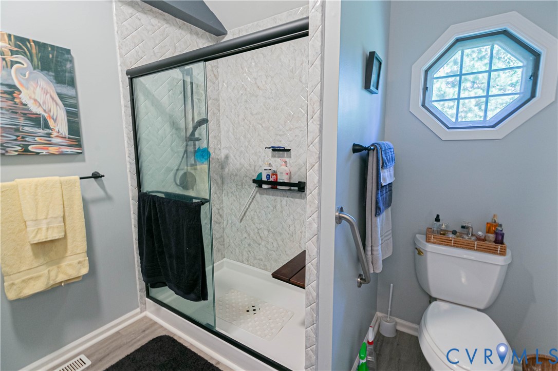 401 Loyalist Drive Ruther Glen, VA 22546 - Photo 28 of 45 a bathroom with a toilet and a shower curtain