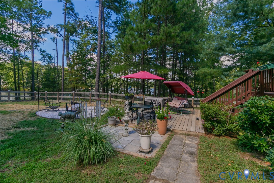 401 Loyalist Drive Ruther Glen, VA 22546 - Photo 7 of 45 a view of a chair and tables under an umbrella