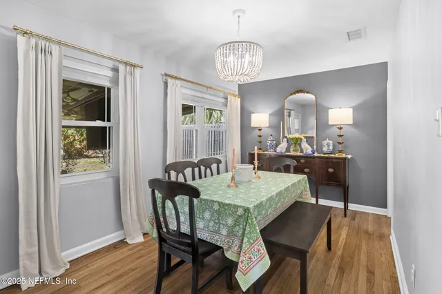 a view of a dining room with furniture a chandelier and wooden floor