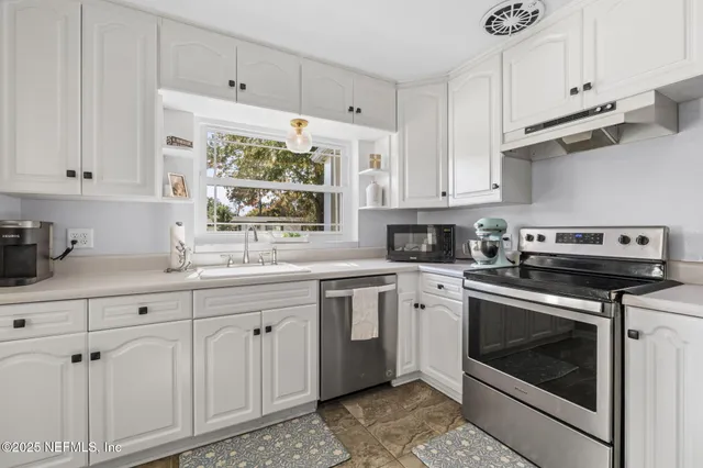 a kitchen with stainless steel appliances a refrigerator sink and stove