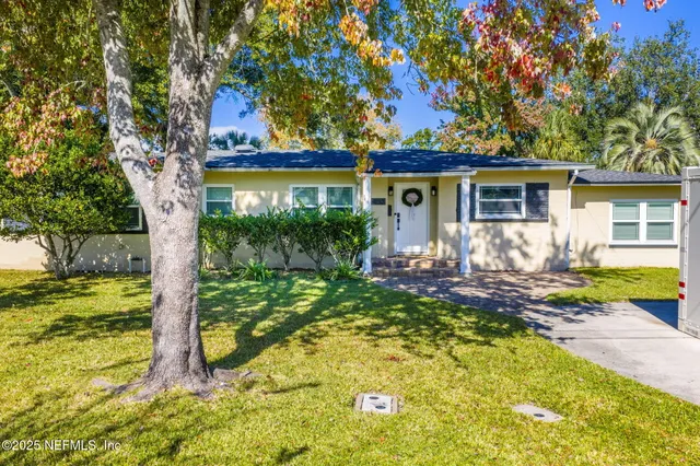 a view of a house with backyard and sitting area