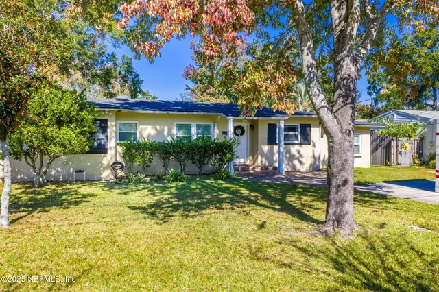 a view of a house with backyard and sitting area