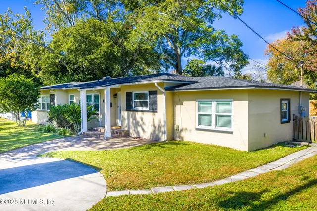 a view of a house with backyard and sitting area