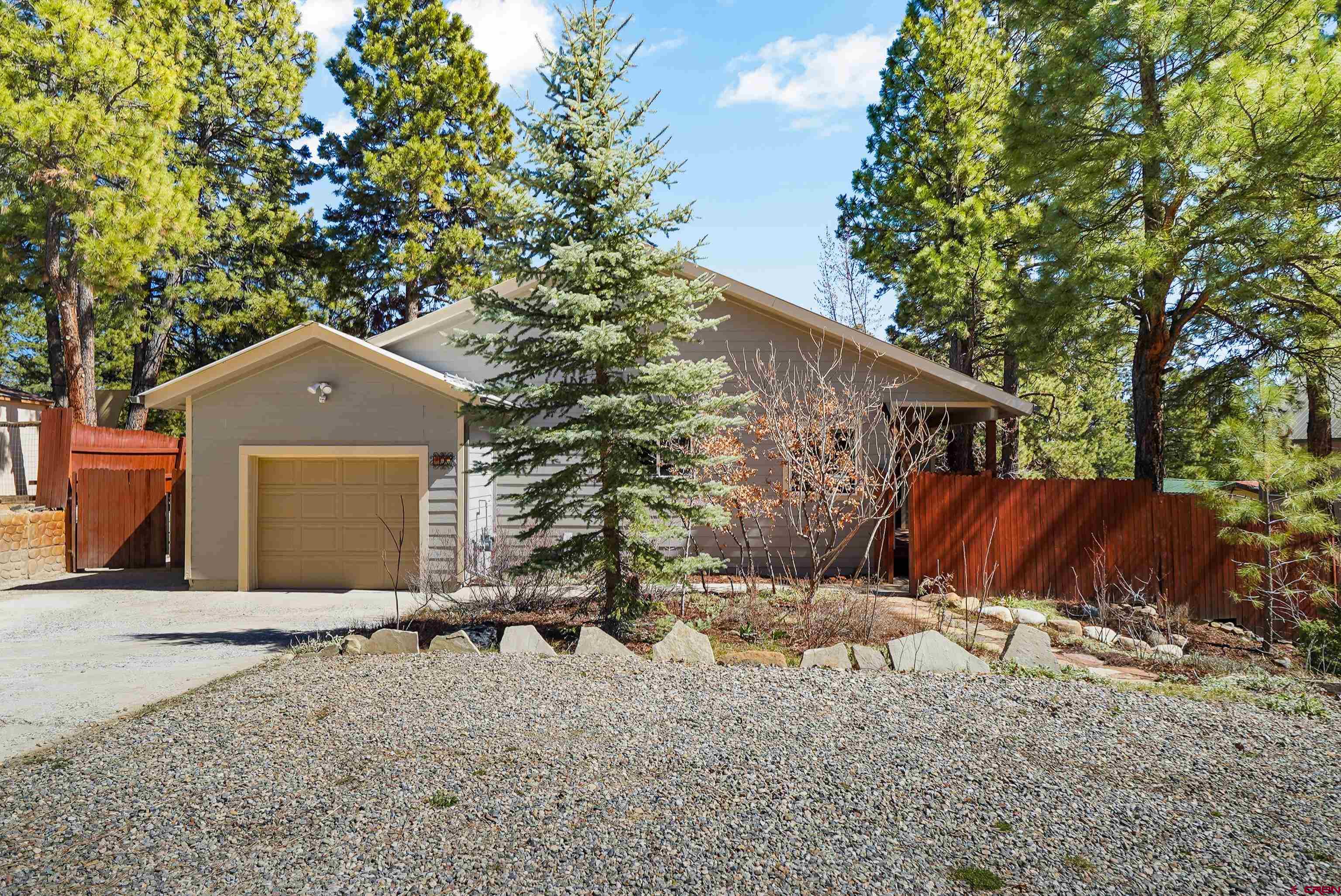 100 Westridge Road Durango, CO 81303 - Photo 36 of 39 a backyard of a house with large trees and outdoor seating