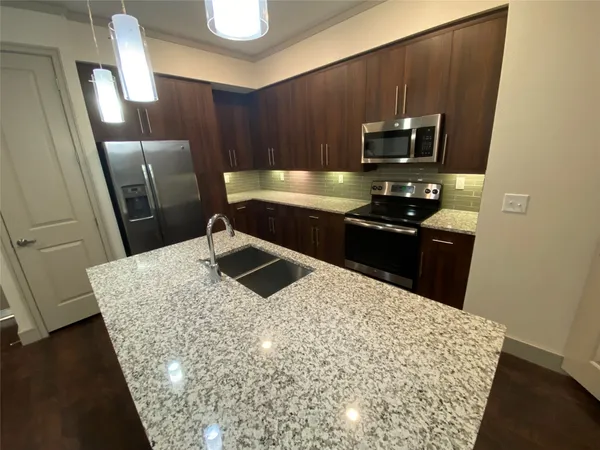 a kitchen with stainless steel appliances wooden cabinets a refrigerator and a sink