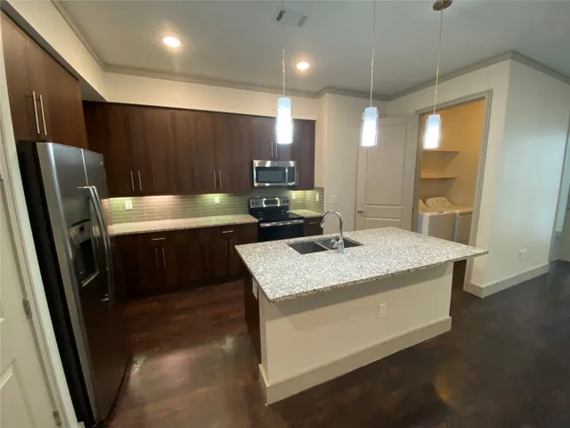 a kitchen with a sink a refrigerator and a stove