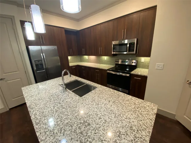 a kitchen with stainless steel appliances wooden cabinets and granite counter tops