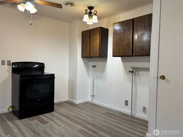 a view of a hallway with wooden floor and cabinet