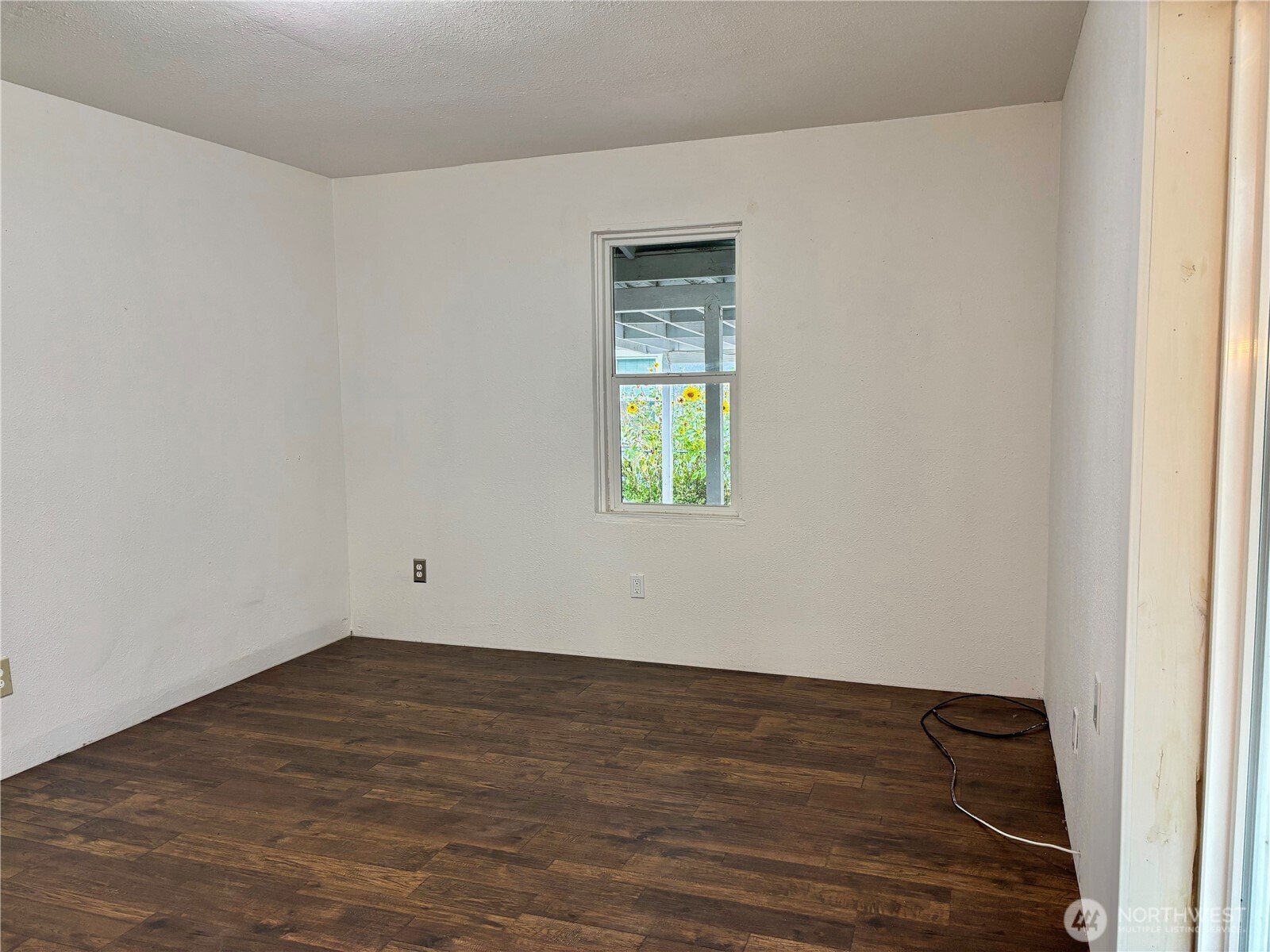 2207 West Spruce Street Moses Lake, WA 98837 - Photo 17 of 18 a view of an empty room with wooden floor and a window