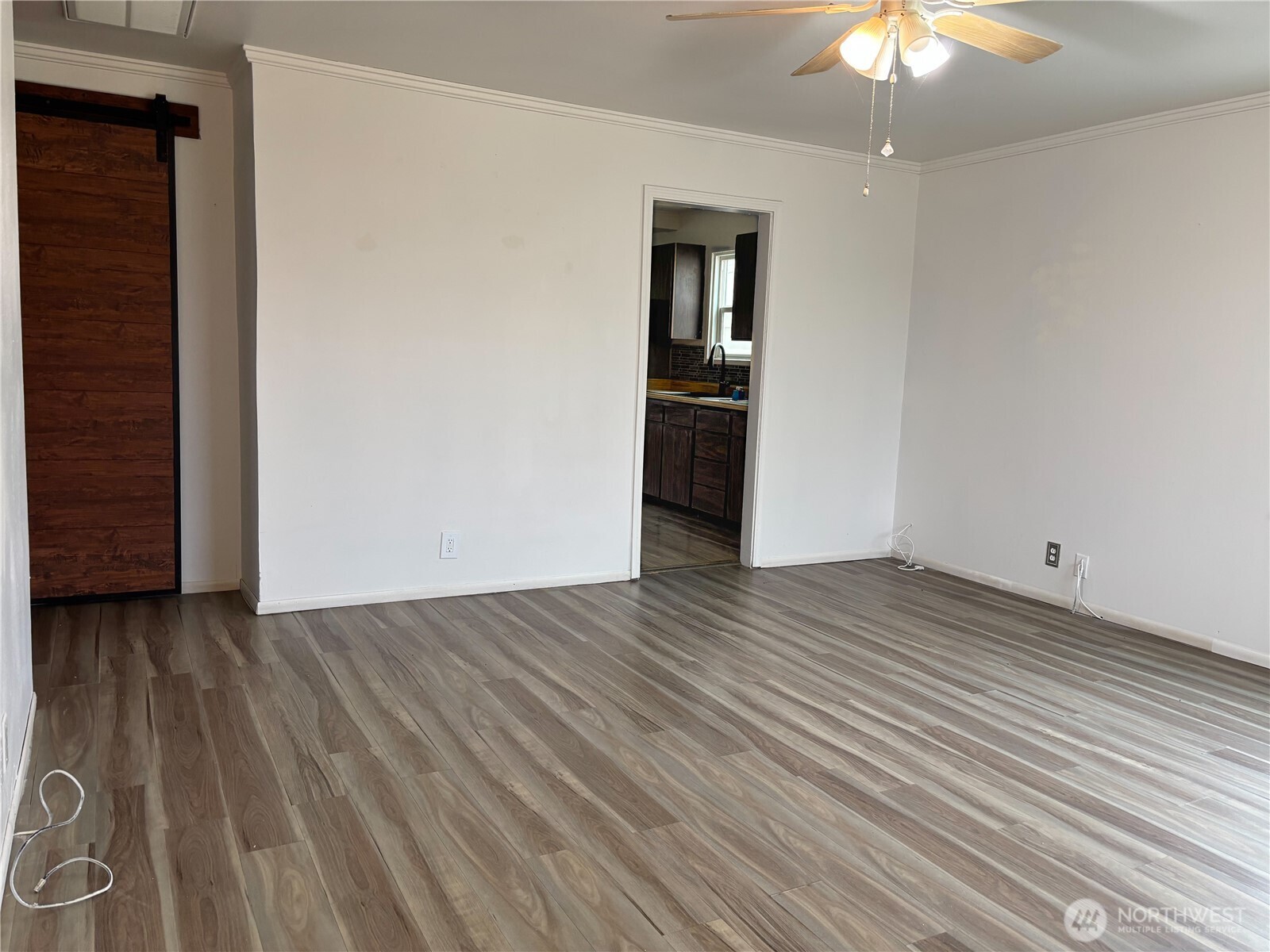 2207 West Spruce Street Moses Lake, WA 98837 - Photo 9 of 18 an empty room with wooden floor chandelier fan and windows