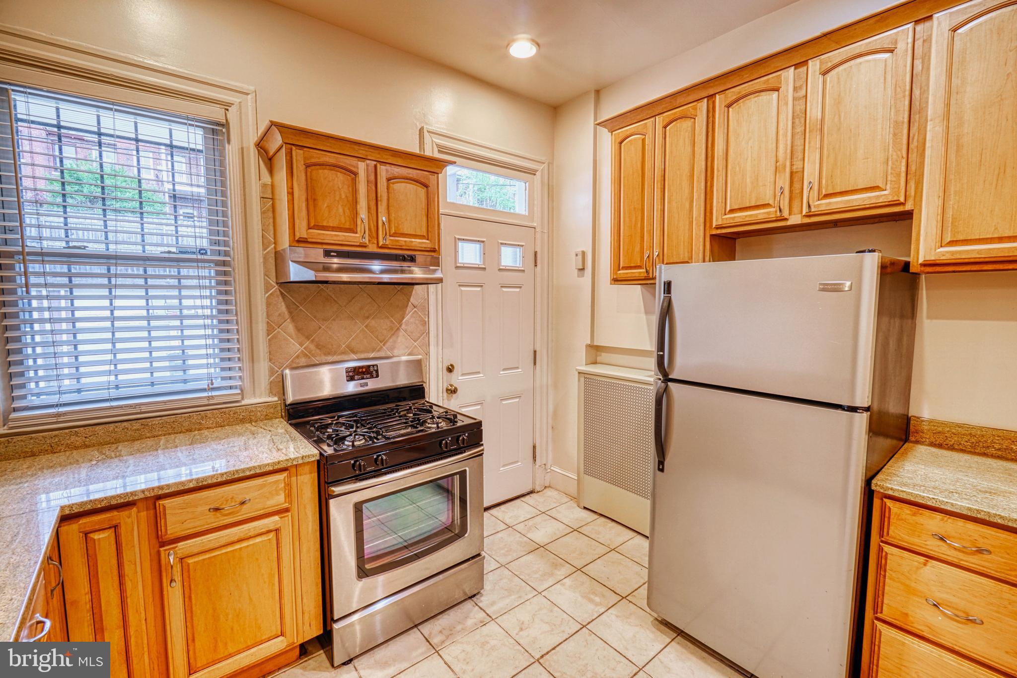 1821 Kilbourne Place Northwest Washington, DC 20010 - Photo 13 of 40 a kitchen with stainless steel appliances granite countertop a refrigerator sink and cabinets