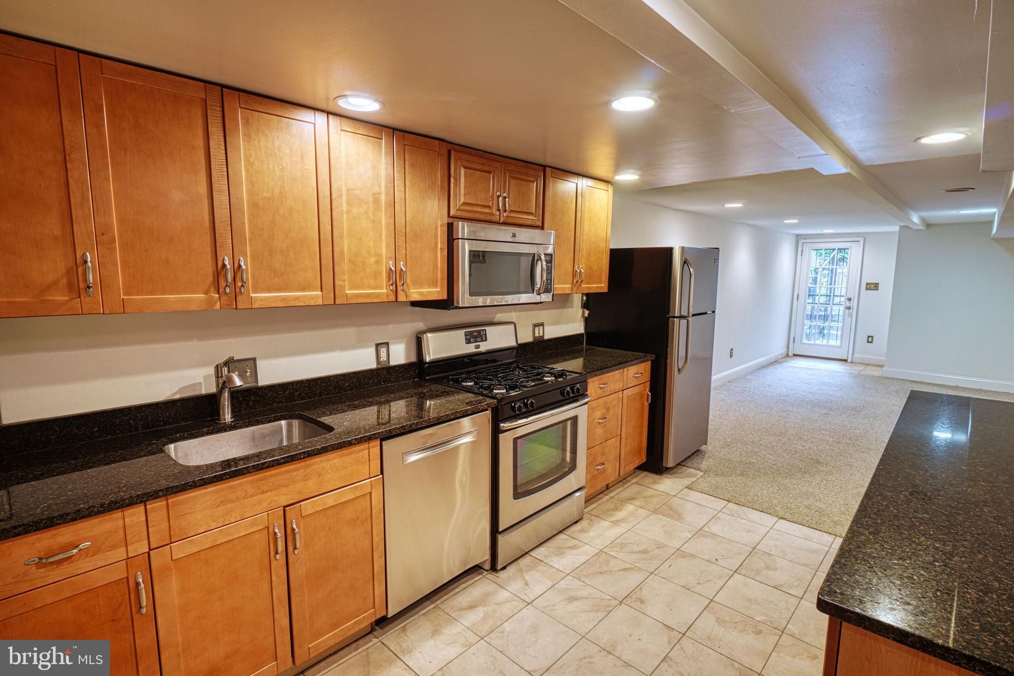 1821 Kilbourne Place Northwest Washington, DC 20010 - Photo 30 of 40 a kitchen with stainless steel appliances granite countertop a sink stove and refrigerator