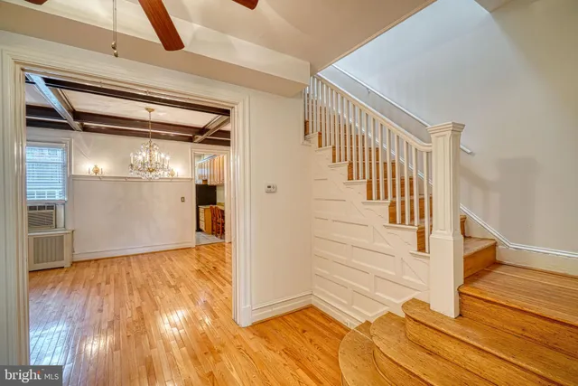 a view of a hallway with wooden floor and chandelier