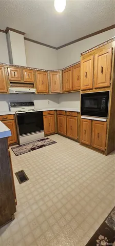 a kitchen with stainless steel appliances a stove a microwave and white cabinets