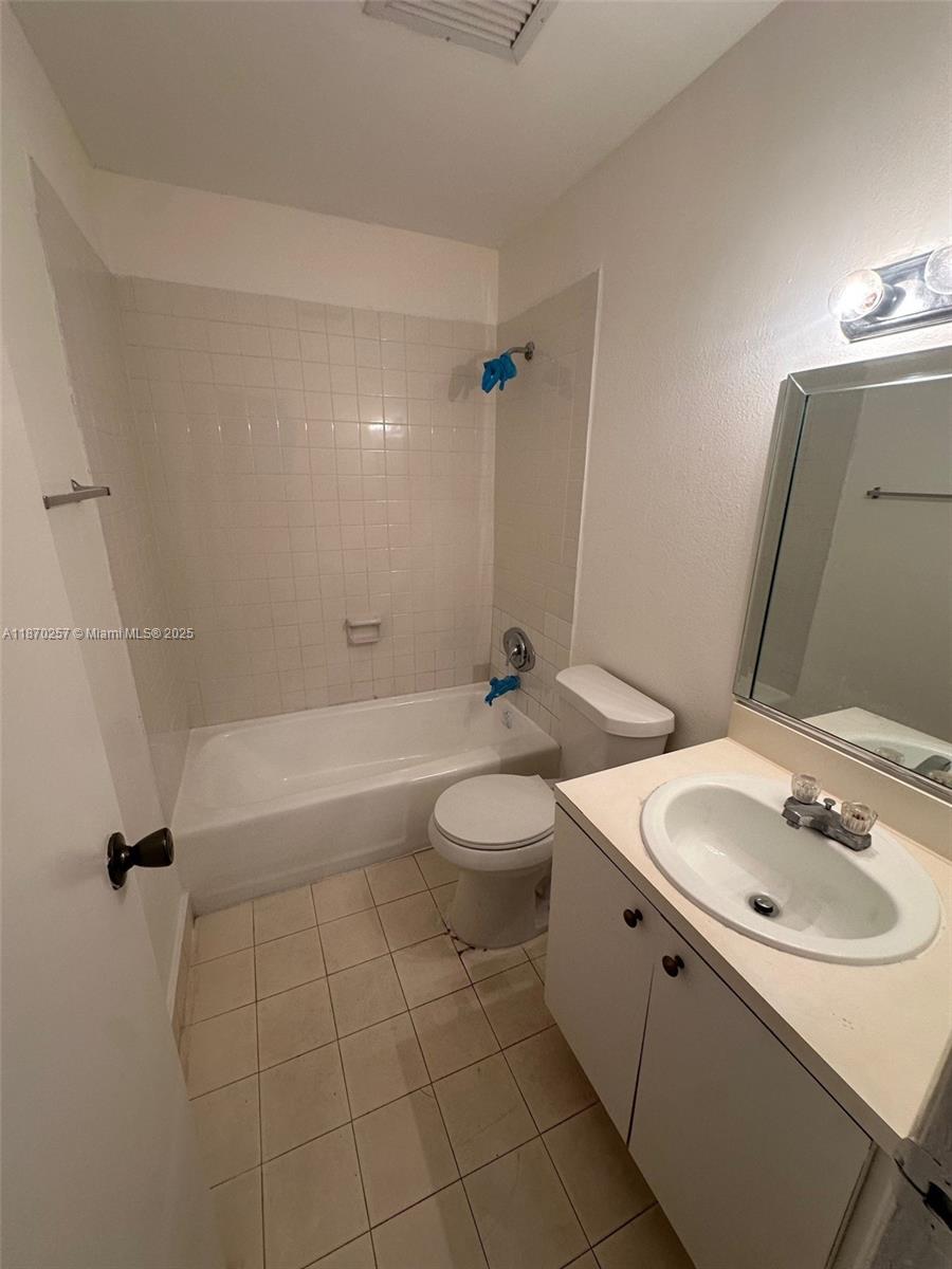 17911 Northwest 68th Avenue, Unit N206 Hialeah, FL 33015 - Photo 2 of 10 a bathroom with a sink a toilet and shower