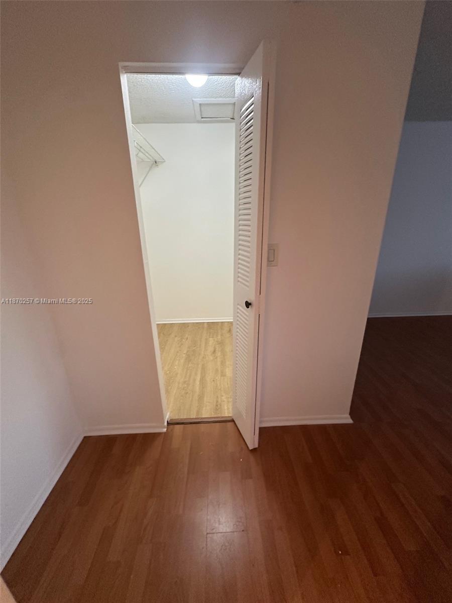 17911 Northwest 68th Avenue, Unit N206 Hialeah, FL 33015 - Photo 4 of 10 an empty room with wooden floor and closet