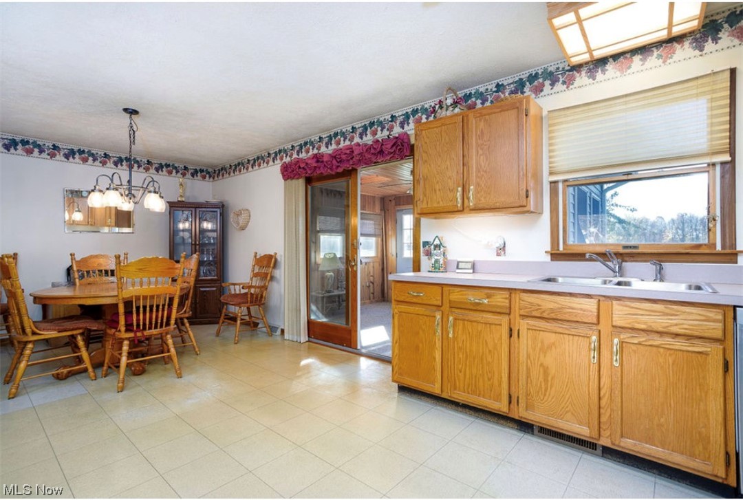 9066 Crow Road Litchfield, OH 44253 - Photo 17 of 28 Kitchen with a chandelier, sink, decorative light fixtures, and light tile floors