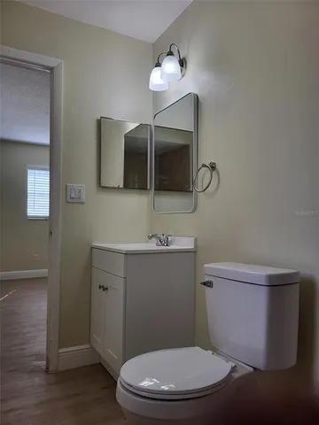 a bathroom with a toilet a sink and mirror