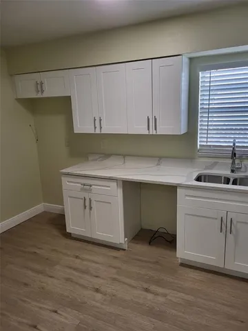 a kitchen with a sink cabinets and a window