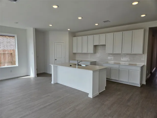 a kitchen with a white cabinets stove top oven and sink