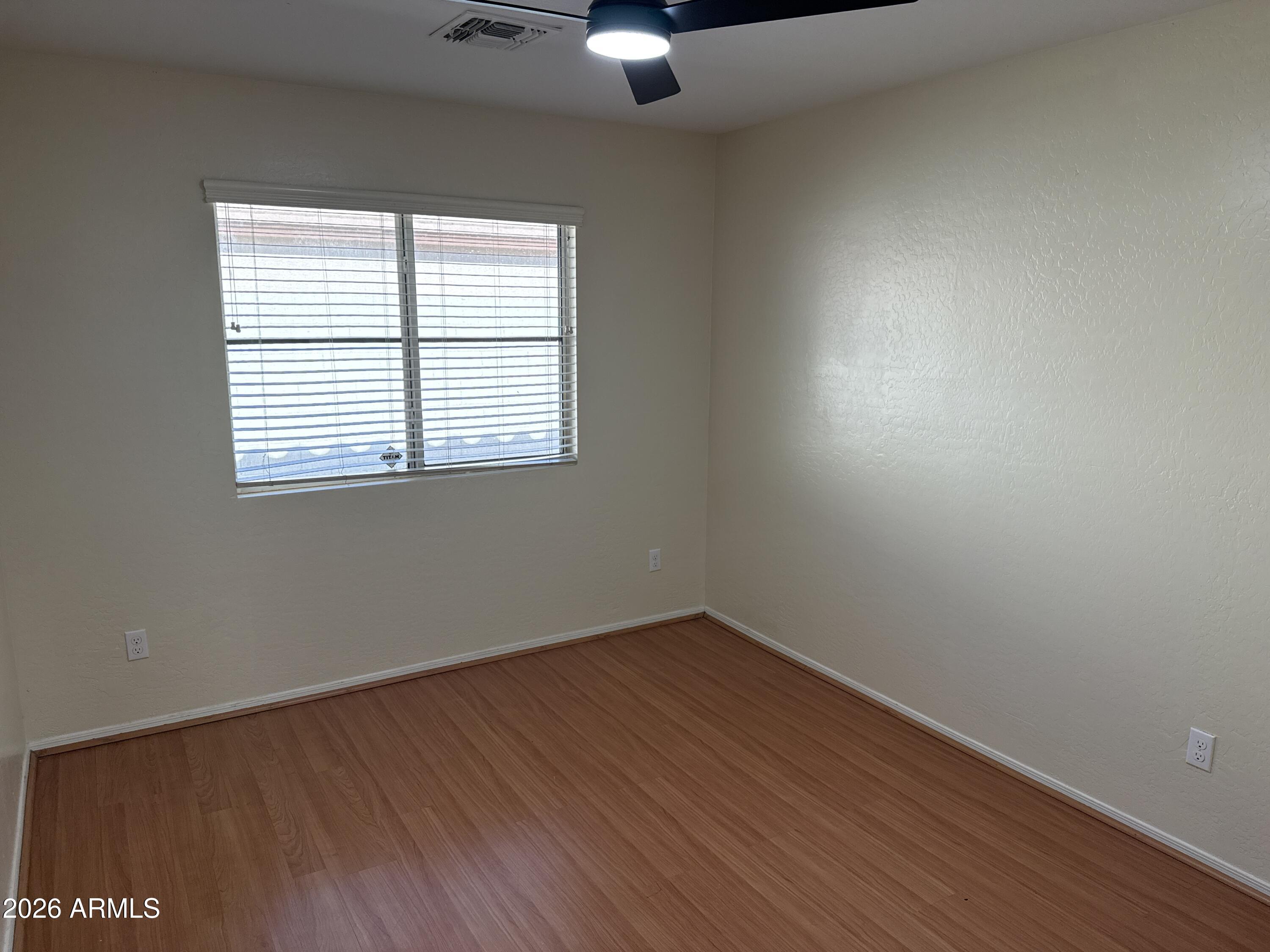 9630 West Reno View Drive Peoria, AZ 85345 - Photo 11 of 21 an empty room with wooden floor and windows