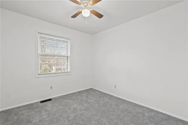 an empty room with a chandelier fan