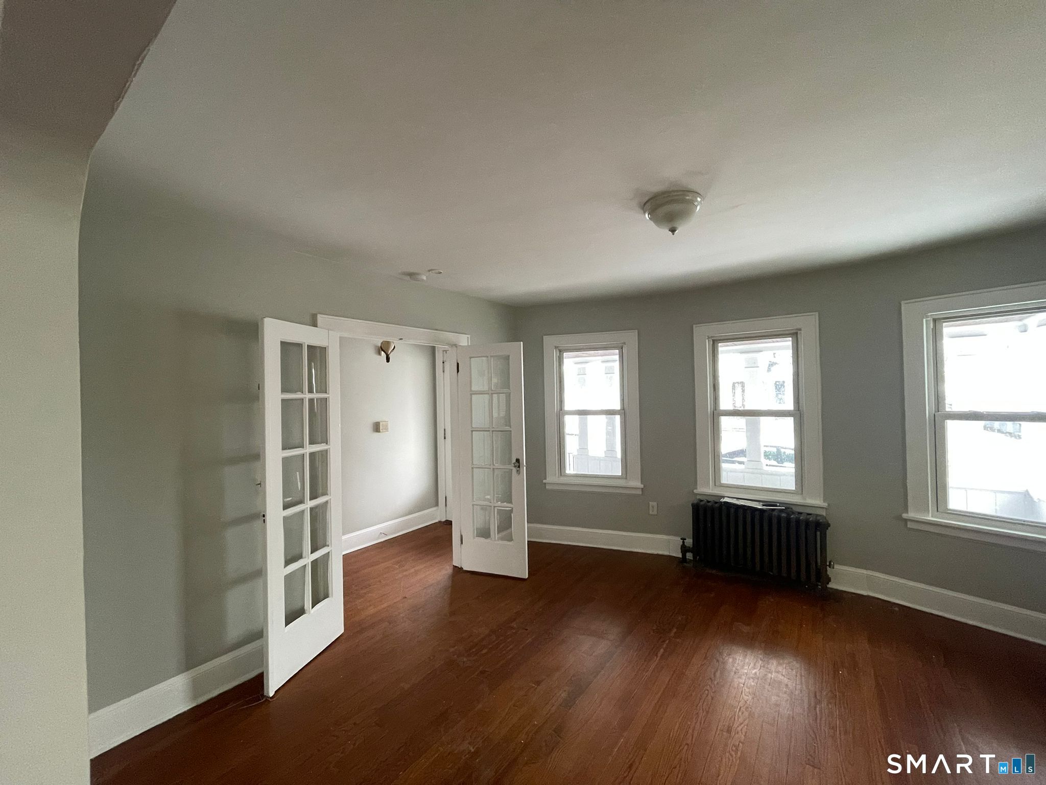 67 Kent Avenue Bridgeport, CT 06610 - Photo 11 of 11 an empty room with wooden floor and windows
