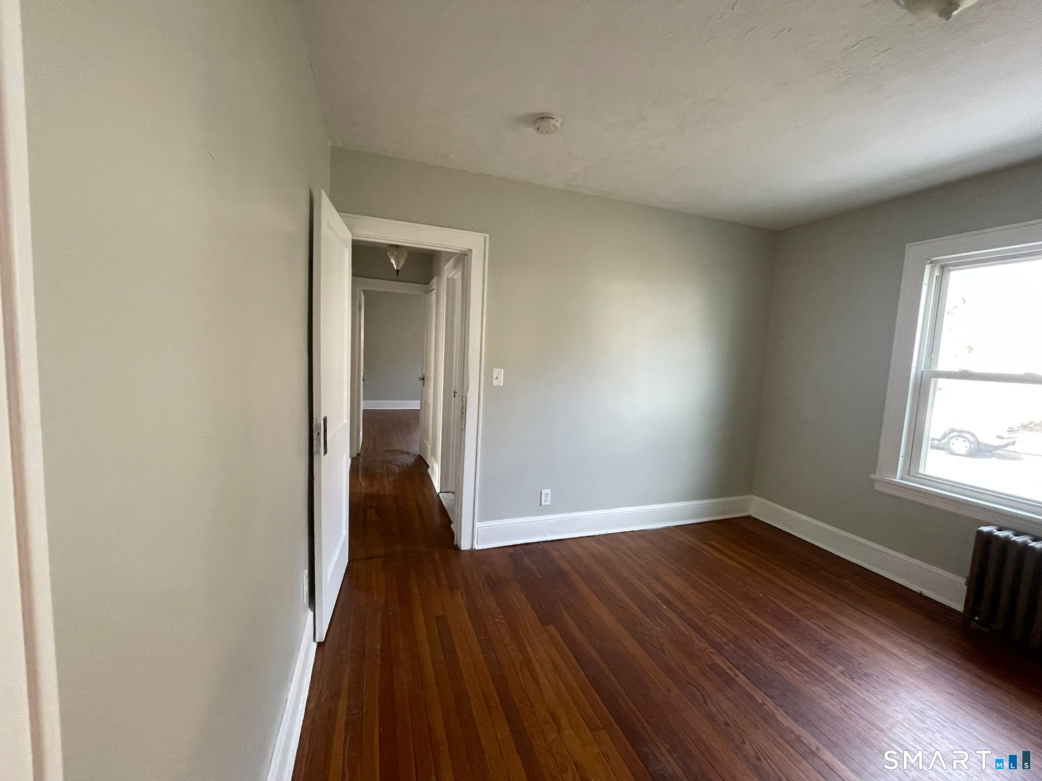 67 Kent Avenue Bridgeport, CT 06610 - Photo 9 of 11 an empty room with wooden floor and windows