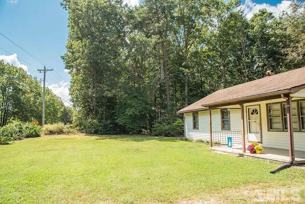 2900 Dink Ashley Road Timberlake, NC 27583 - Photo 15 of 15 a view of a white house with a large pool and large trees