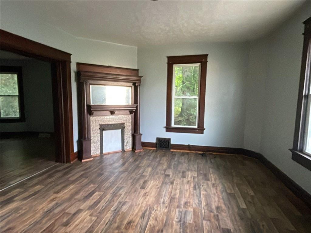 425 East Reynolds Street New Castle, PA 16101 - Photo 3 of 13 an empty room with wooden floor a fireplace and windows