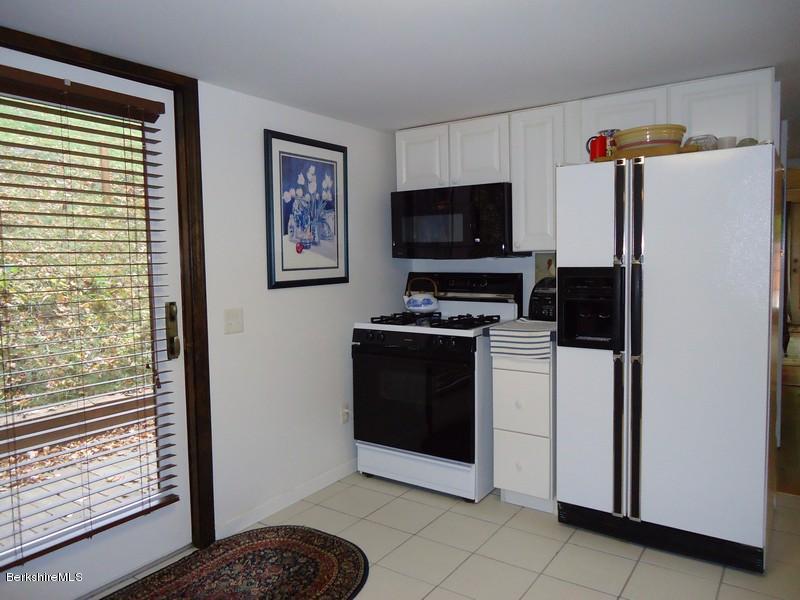 2359 North Main Road Otis, MA 01253 - Photo 19 of 32 a kitchen with stainless steel appliances a refrigerator and a stove top oven