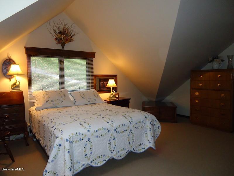 2359 North Main Road Otis, MA 01253 - Photo 25 of 32 a bedroom with a bed and a chandelier