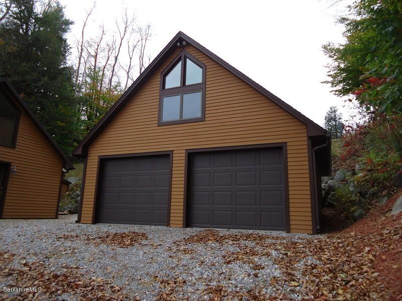 2359 North Main Road Otis, MA 01253 - Photo 6 of 32 a front view of a house with a yard and garage