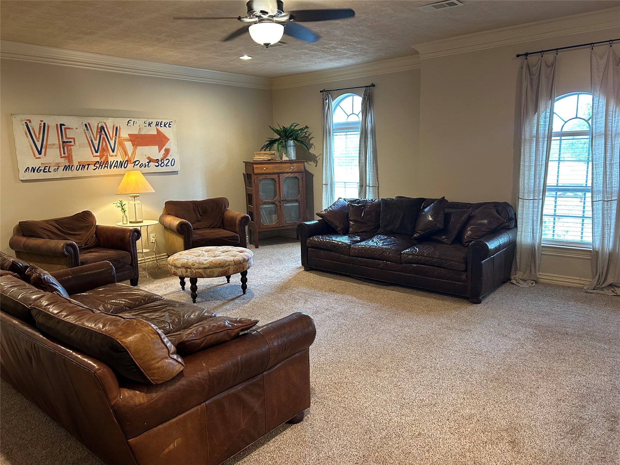 329 Flash Circle Luling, TX 78648 - Photo 16 of 32 A spacious living room features wall-to-wall carpeting, crown molding, and arched windows.