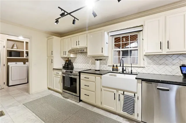 a kitchen with granite countertop a sink stainless steel appliances and cabinets