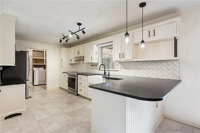 a kitchen with stainless steel appliances granite countertop a sink a stove and a refrigerator