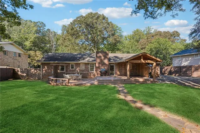 a view of a house with backyard and sitting area