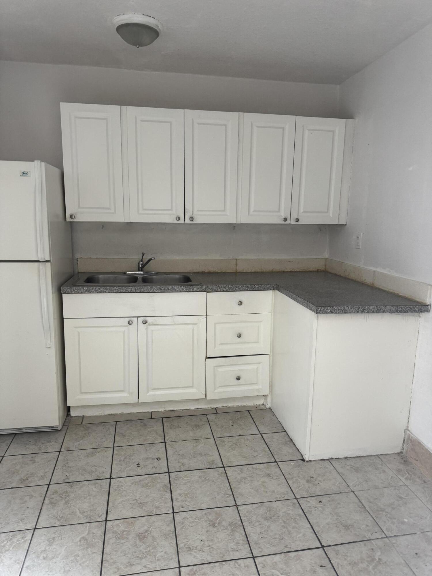 3500 Riverside Drive, Unit 13 Coral Springs, FL 33065 - Photo 12 of 15 a kitchen with white cabinets and a stove top oven