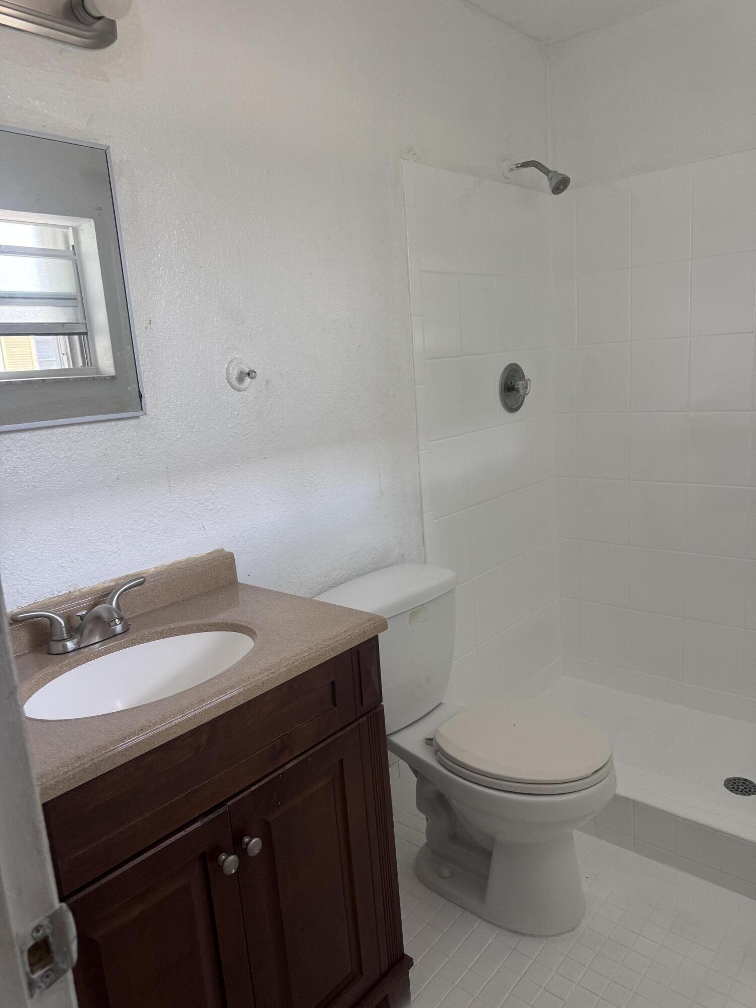 3500 Riverside Drive, Unit 13 Coral Springs, FL 33065 - Photo 4 of 15 a bathroom with a sink a toilet and a mirror