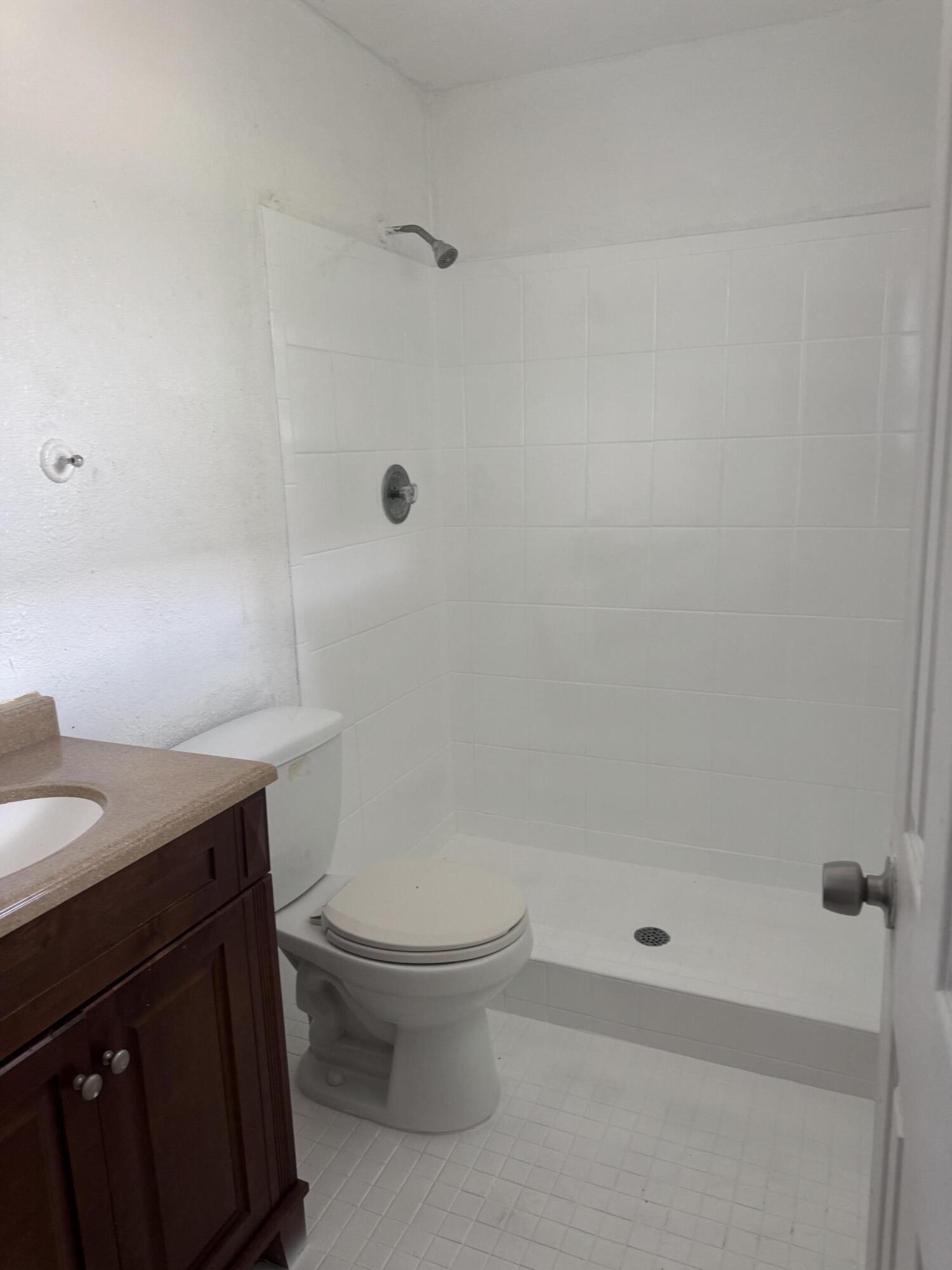 3500 Riverside Drive, Unit 13 Coral Springs, FL 33065 - Photo 5 of 15 a bathroom with a granite countertop sink a toilet and shower