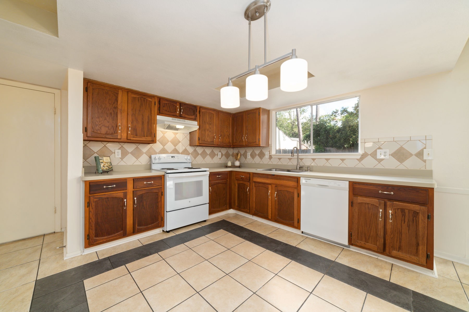 25402 Mill Pond Lane Spring, TX 77373 - Photo 13 of 22 a kitchen with a sink cabinets stainless steel appliances and a window