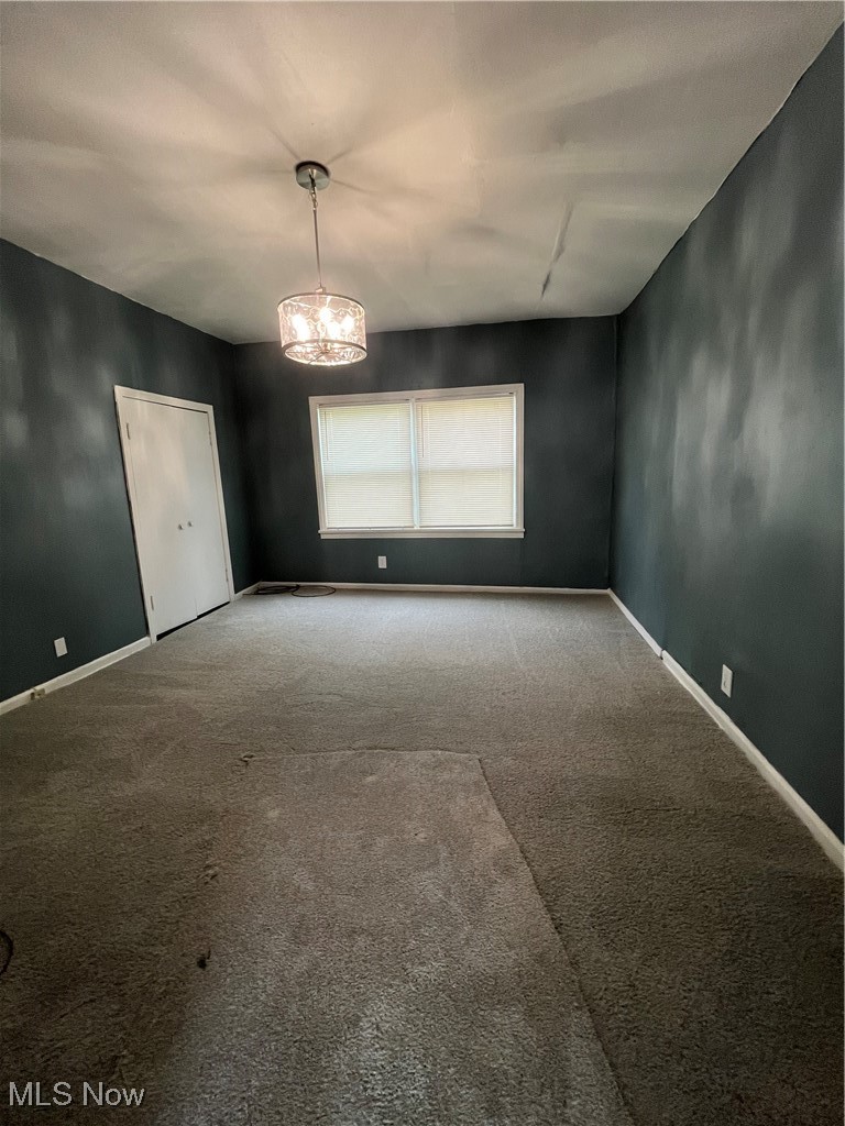 1264 Diagonal Road Akron, OH 44320 - Photo 7 of 23 Unfurnished room with carpet, a chandelier, and baseboards