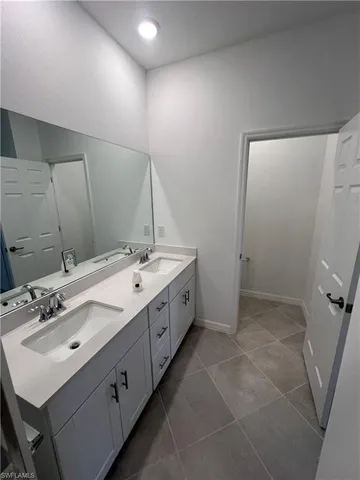 a spacious bathroom with a double vanity sink and a mirror